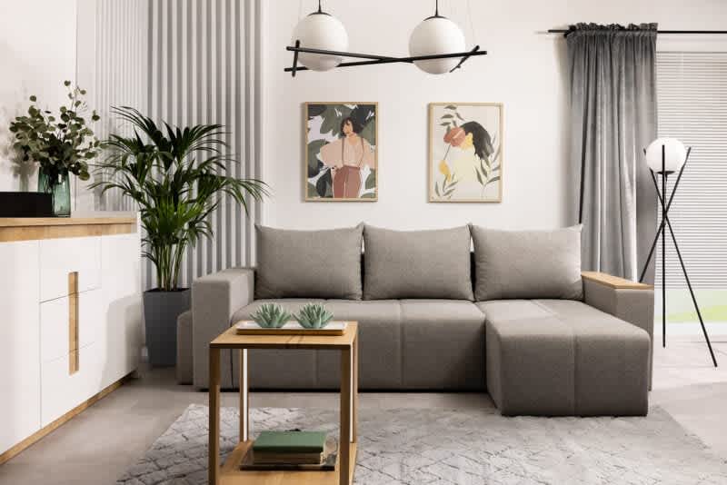 Mały salon z wielofunkcyjną szarą sofą modułową, minimalistycznym drewnianym stolikiem kawowym i naturalnym wystrojem maksymalizującym przestrzeń i styl